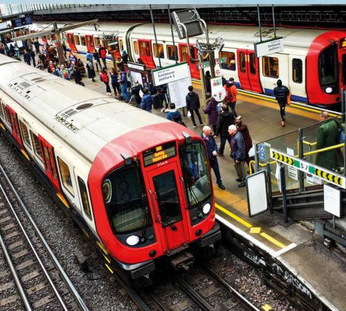 A bright photo of two trains waiting to depart at a train station.