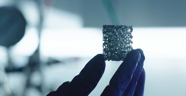 A cube of a matrix like substance being held in a latex gloved hand