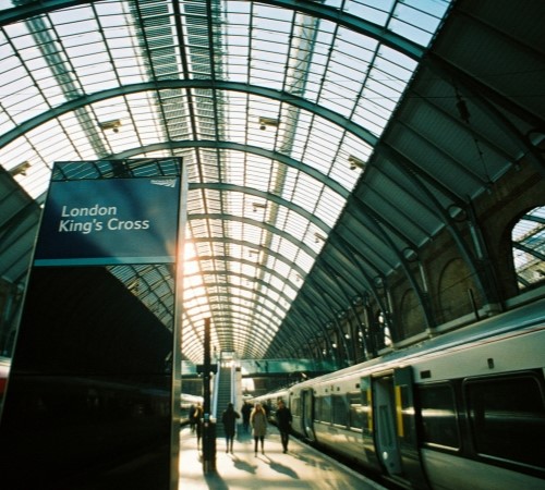 A dark image of London King's Cross station looking up at the glass roof.